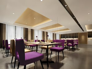 A modern conference room with tables and chairs, large windows with curtains, and a high ceiling with recessed lighting.