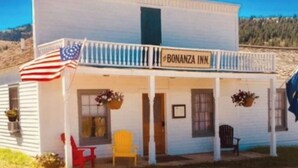 Un bâtiment blanc doté d’un balcon et d’une enseigne sur laquelle on peut lire « BONANZA INN ».