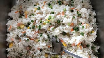 A close-up of a dish with rice, vegetables, and green onions.