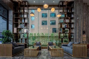 A modern library with bookshelves, seating areas, and hanging lights. - HTYS Boutique Hotel (Dongguan)