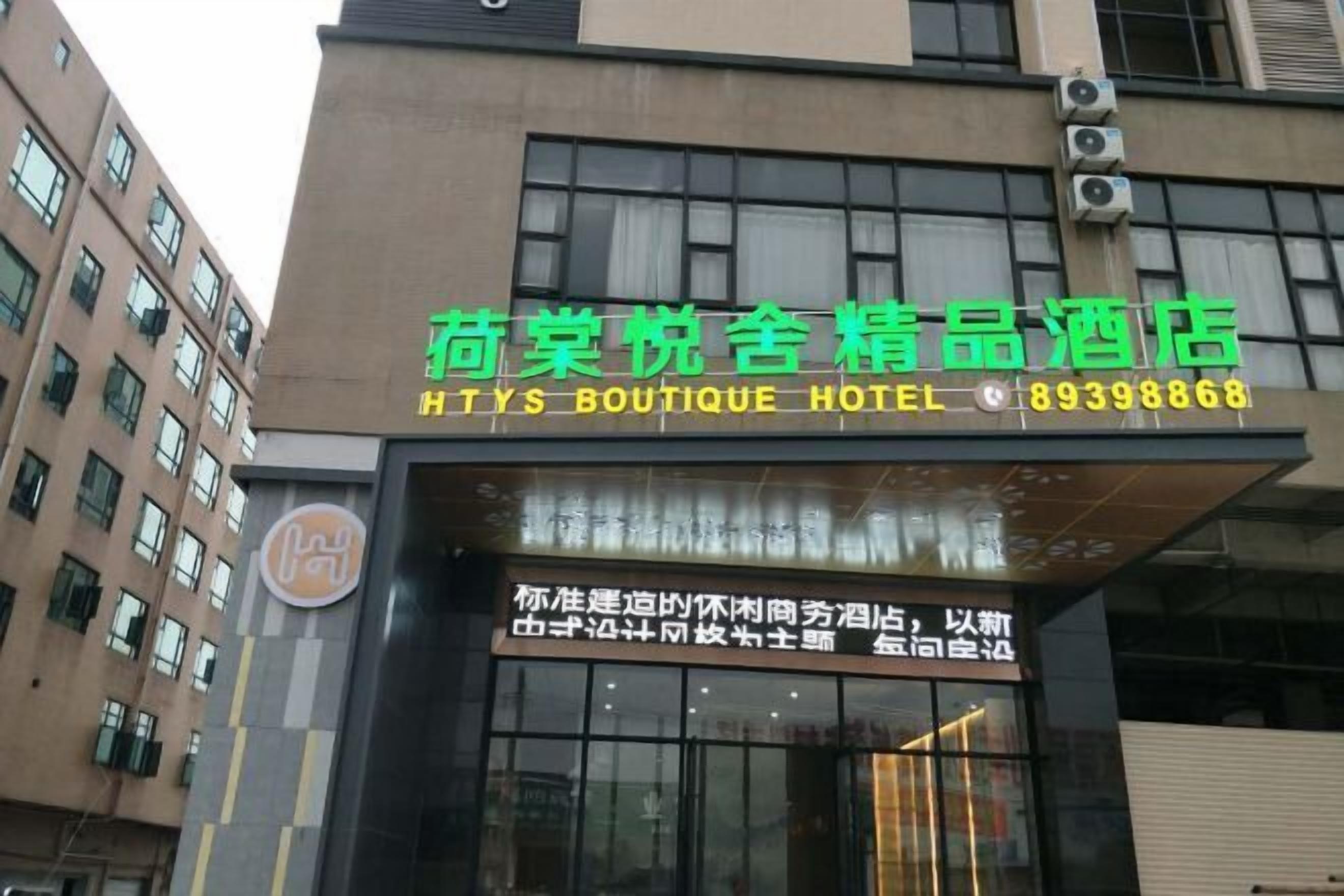 Señal de hotel con caracteres chinos y un número de teléfono.