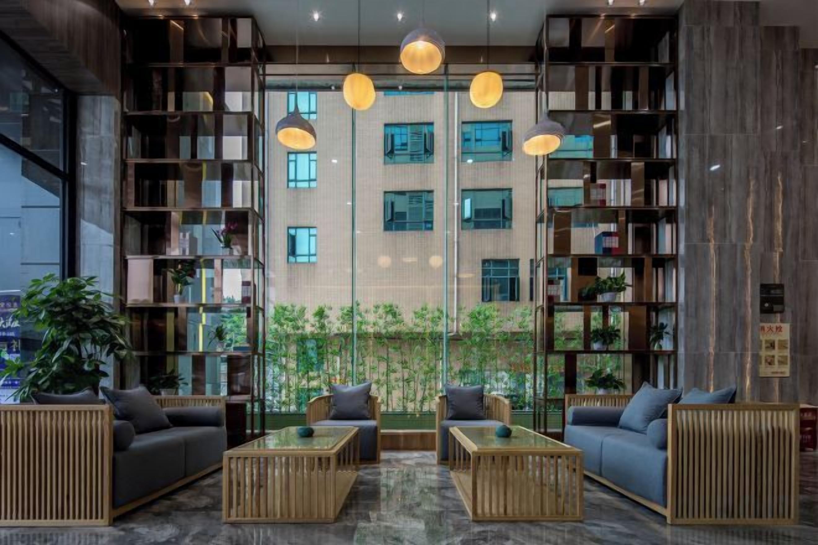 A modern interior with a seating area, bookshelves, and a view of a building.