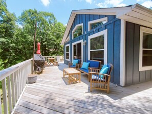 A wooden deck with outdoor furniture, a barbecue grill, and a blue building with large windows. - Quiet Mountain 3/2 Home with Spectacular Views, Additional bedroom for extra (Hot Springs)