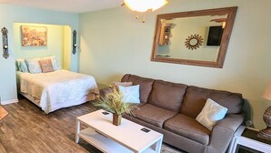 A living room with a ceiling fan, a bed, a couch, and a coffee table. - Oceanfront Getaway,  Directly on the Beach with Amazing Views (Surfside Beach)