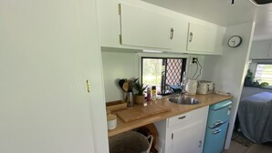 A compact kitchenette with a sink, a toaster, and a small refrigerator. - 'Alice' Crescent Head's coolest retro caravan (Crescent Head)