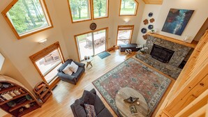 A spacious living area with large windows, a fireplace, and a cozy seating arrangement. - Cozy Dog Friendly, Private Dock & Fire Pit (Oakland)