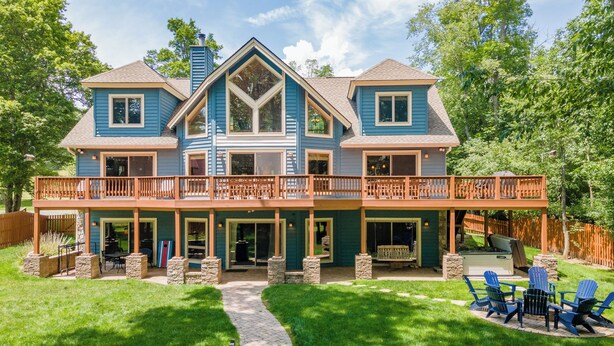 A two-story house with a covered patio and outdoor seating area. - Cozy Dog Friendly, Private Dock & Fire Pit (Oakland)