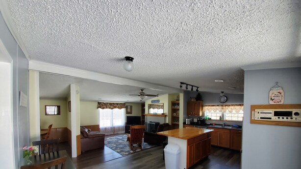 Amplia sala de estar con una mesa de comedor, un sofá y una cocina con armarios de madera y una isla integrada.