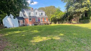 A residential property with a two-story house, a fenced yard, and a white garage. - Magnolia Breeze (Norfolk)