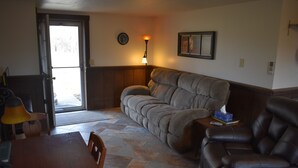 A living room with a sofa, a dining table, and a lamp.