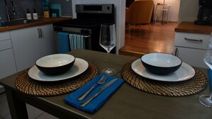 A modern kitchen with two bowls on a table, a wine glass, and a blue napkin. - Lovely 1 Bedroom Garden flat in Victorian Building (San Francisco)