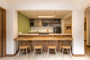 A modern kitchen with a central island, bar stools, and built-in appliances. - Provenza*-3BR/Private Jacuzzi/ Hammock Net (Medellín)