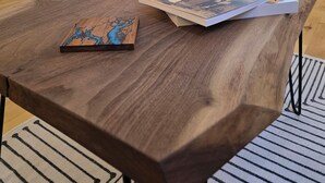 Una habitación acogedora con una mesa de madera, una vela encendida y un libro.