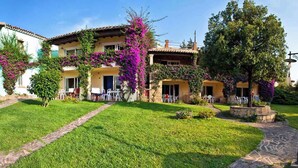 A two-story building with a garden pathway leading to the entrance. - Holiday home Two room apartment with air conditioning (Porto Rotondo)