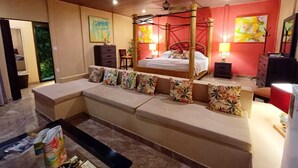 A bedroom with a four-poster bed, a sofa bed, a desk, and a chair.