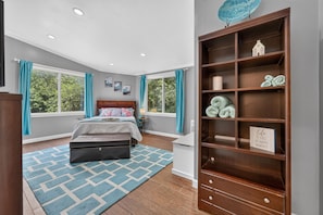 A bedroom with a bed, a nightstand, a dresser, and a window with curtains. - Rare find! Spacious home near wedding venues & CB/OMA. Perfect for entertaining! (Glenwood)