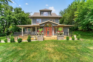 A two-story house with a front porch, stone steps, and a red door. - Rare find! Spacious home near wedding venues & CB/OMA. Perfect for entertaining! (Glenwood)