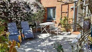 A patio with outdoor furniture, a brick wall, and a window. - Hook - Holiday apartment Hook - with south-facing terrace, very quiet location (Midlum)
