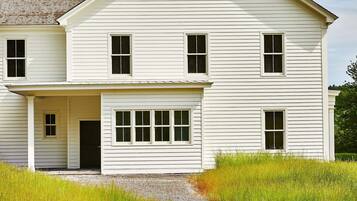 A two-story white house with a front porch and a chimney.