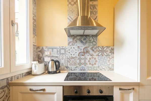A kitchen with a gas stove, oven, and a patterned backsplash.