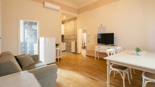 Un salon moderne avec un canapé, une table à manger et un téléviseur.