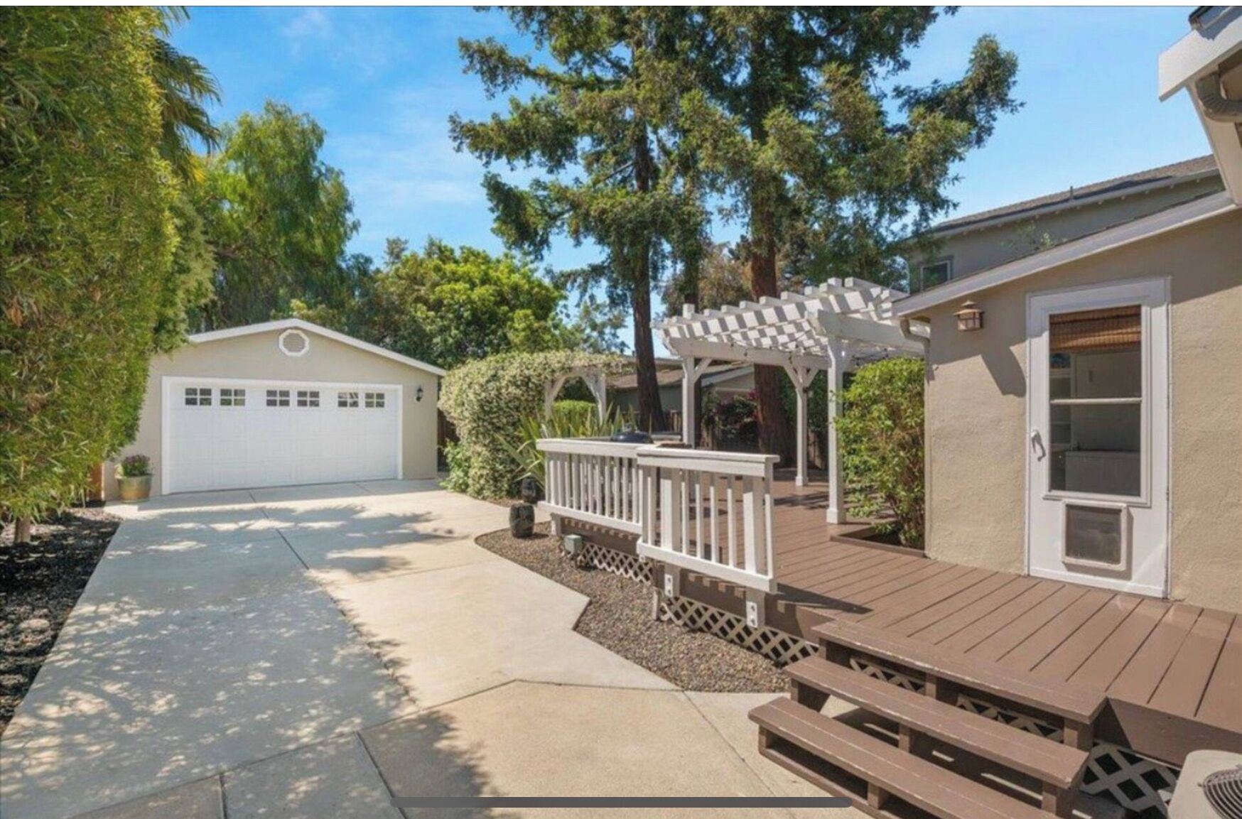 Un immobile residenziale con garage, patio coperto e terrazza in legno.