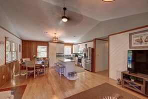 Una cocina amplia con armarios de madera, una isla central y electrodomésticos de acero inoxidable.