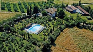 An aerial view of a property with a swimming pool, multiple buildings, and surrounding greenery. - Apartment Mimosa by Interhome (Peccioli)
