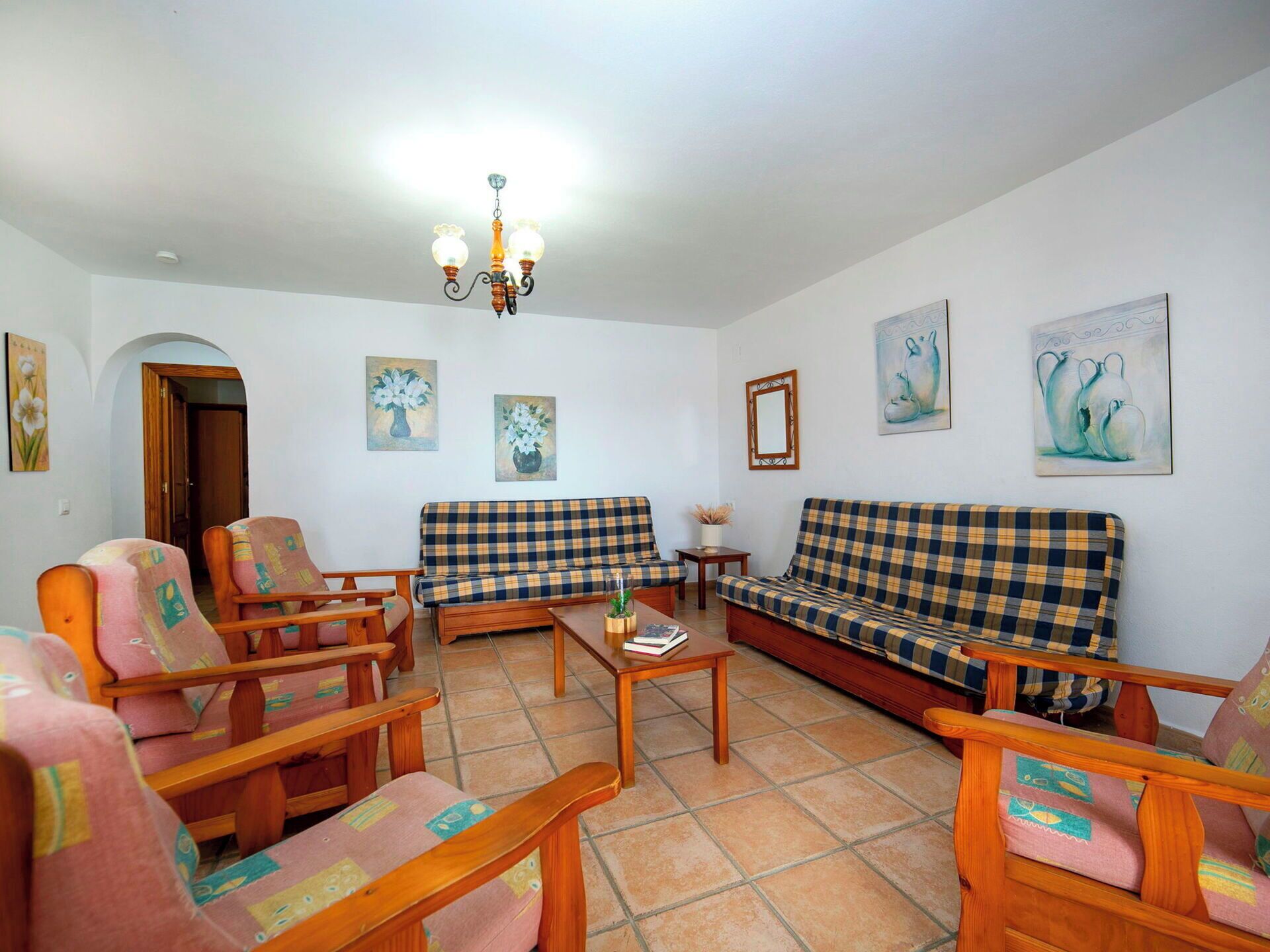 A living room with a sofa, chairs, a coffee table, and artwork on the walls.