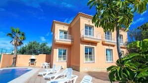 A two-story building with a swimming pool, sun loungers, and a palm tree. - Stunning private villa for 17 people with WIFI, private pool, A/C, TV, patio and pets allowed (Calpe)