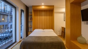 A modern hotel room with a large bed, wooden wardrobe, and a TV on the wall. - Northern Star - Studio 1.1 Porto (in the city center) (Porto)