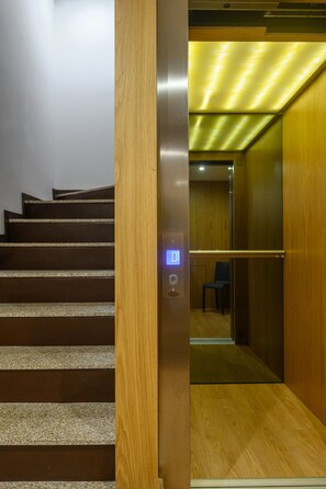 Un ascenseur avec un intérieur en bois, un écran numérique et un siège.