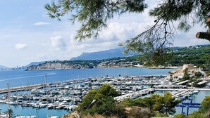 A marina with boats docked, a staircase leading down, and a coastal view.
