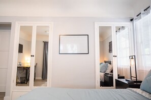 Une chambre à coucher avec un lit, une table de chevet, une lampe et un tableau encadré au mur.