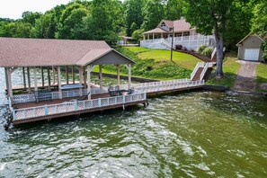 A covered dock with seating, a small pavilion, and a house with a porch and stairs leading to a garage. - The View on Weiss Lake (cedar bluff)