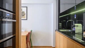 A modern kitchen with wooden cabinets, a black countertop, and a stainless steel oven. - Northern Star - Studio 4.1 Porto (in the city center) (Porto)