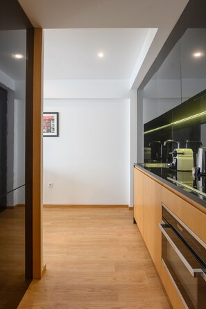 A modern kitchen with wooden cabinets, a black countertop, and stainless steel appliances.
