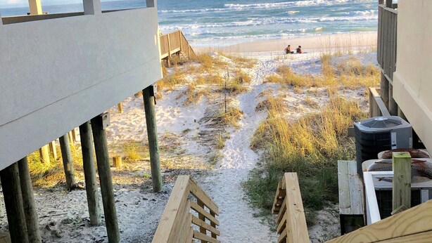 A wooden staircase leading to a sandy beach area with a view of the ocean. - Clean & Ready for Guests! Recently Remodeled, Steps to the Beach! (Miramar Beach)