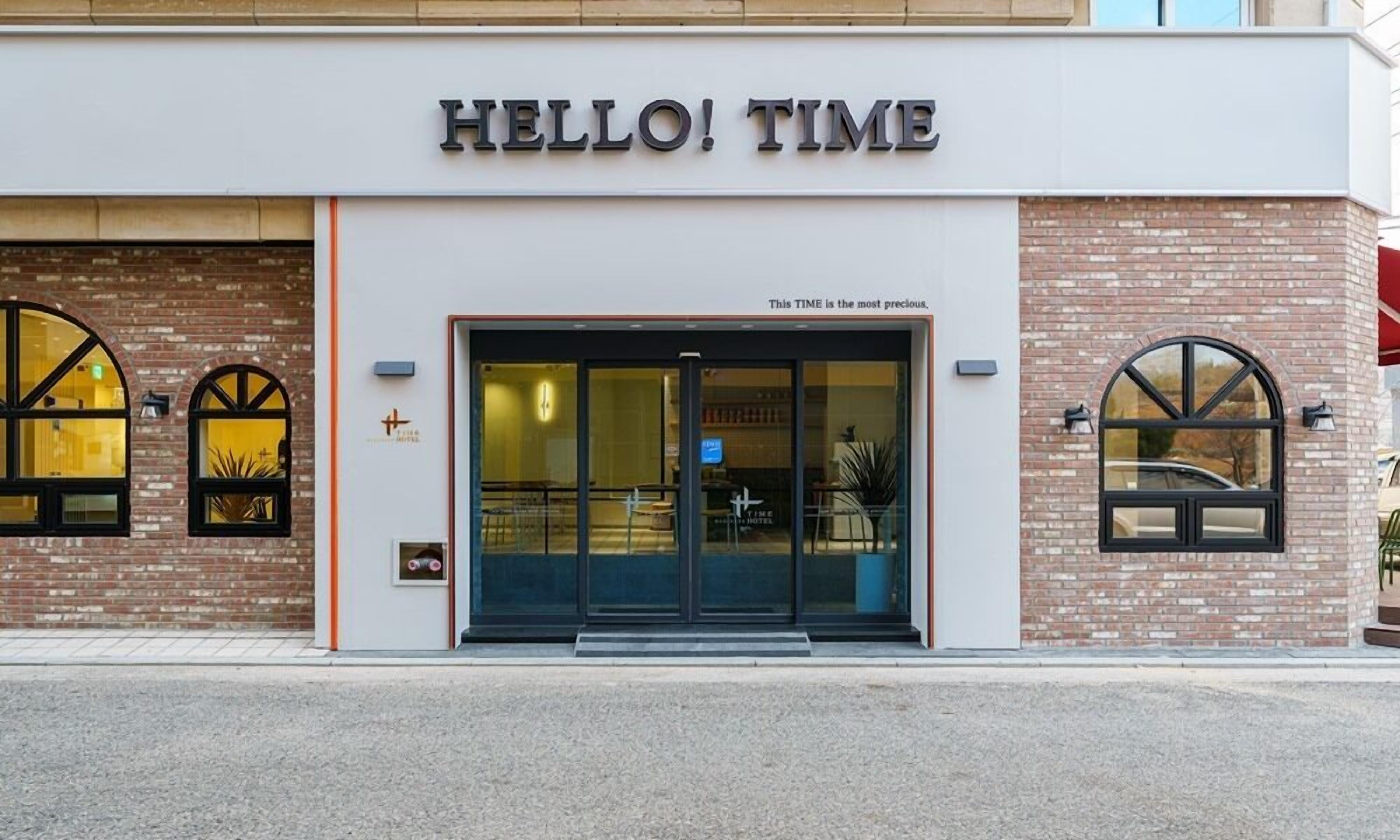 A hotel entrance with the sign "HELLO! TIME" and a quote "This TIME is the most precious."