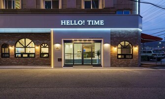 A hotel entrance with a sign reading "HELLO! TIME".