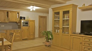 Amplia sala de estar con armarios de madera, comedor y cocina.