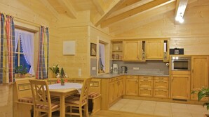 Una cabaña de madera con comedor y cocina.