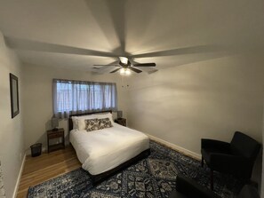 A bedroom with a bed, a ceiling fan, a nightstand, a chair, and a patterned rug. - Flagstaff Hide-a-Way! Walk to downtown! (Flagstaff)