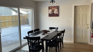 Uma sala de jantar com uma mesa comprida, seis cadeiras e um candelabro.