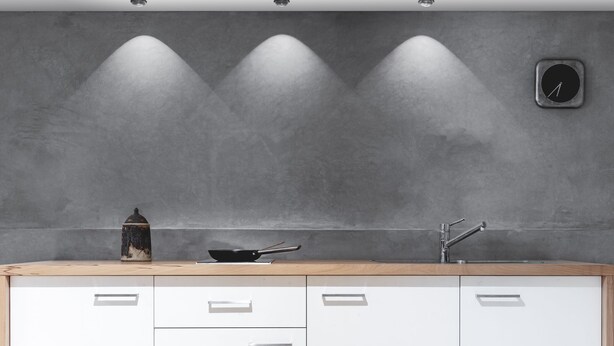 Una cocina con armarios blancos, encimera de madera, estufa y lavabo.