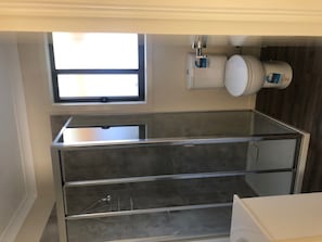 Bathroom features a large mirror, stainless steel sink, and storage.