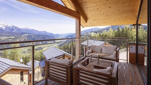 A wooden deck with a sofa and chairs, overlooking a mountainous landscape. - Chalet with panoramic sauna (Schladming - Pichl, Ennstal)