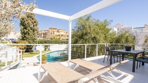 Un espace extérieur abrité comprenant une piscine, des chaises longues et une table.