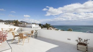 A rooftop terrace with outdoor seating, a view of the sea, and distant mountains. - Apartment "Villa San Salvador" with Sea View, Pool, Wi-Fi & Garden (Nerja)