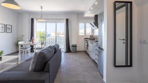 Un apartamento moderno con comedor, cocina y un amplio ventanal con vistas.